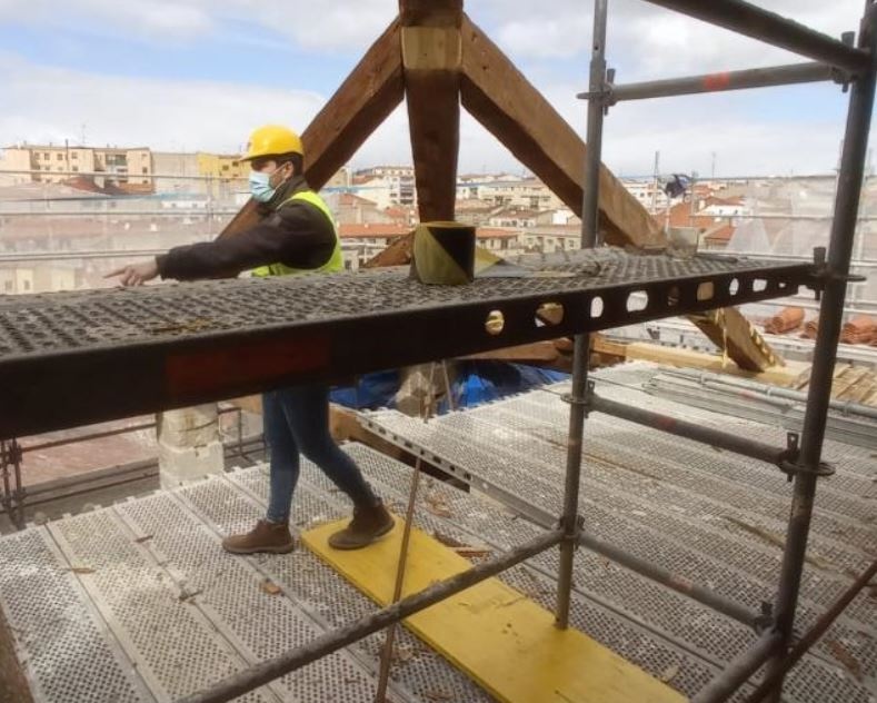 Trabajador sobre andamios